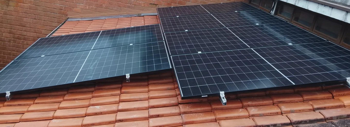 Módulos fotovoltaicos fixados sobre telhado cerâmico.