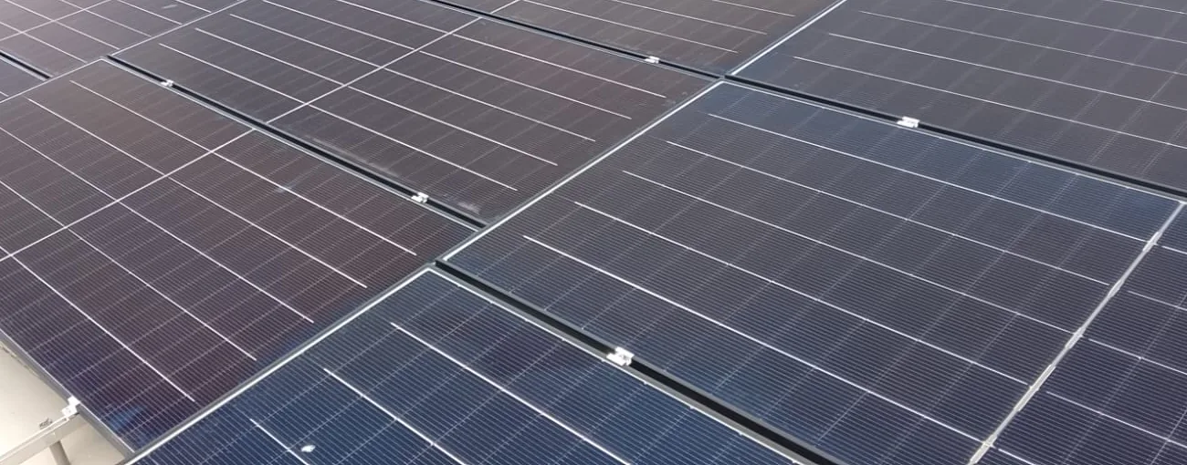 Detalhe de módulos fotovoltaicos e fixações em cobertura residencial de Juquehy.